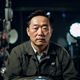 电影史研究者黄俊明的头像，中年男性，电影放映机前，神情专注